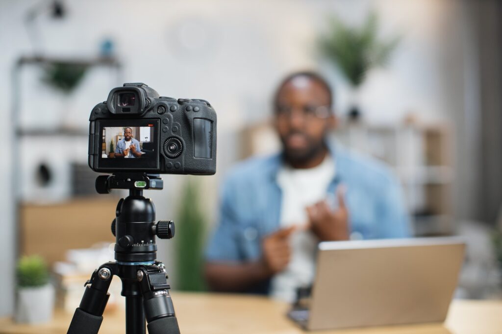 African guy recording new video blog on digital camera