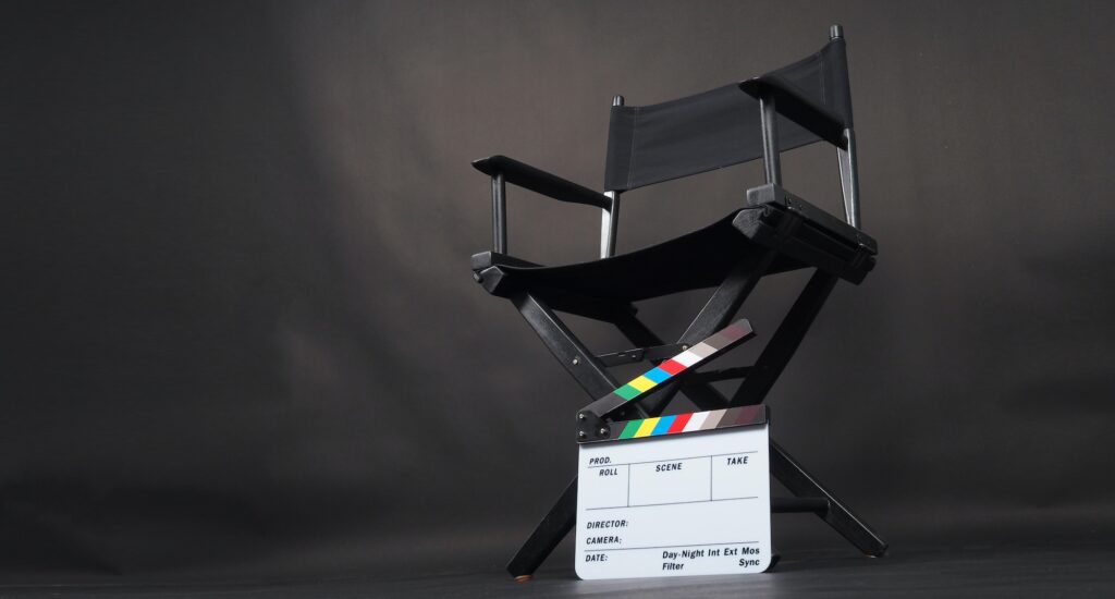 Black director chair and Clapper board on black background.