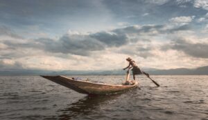 Shan, Myanmar - June, 25 2012: Anonymous fisherman standing on boat