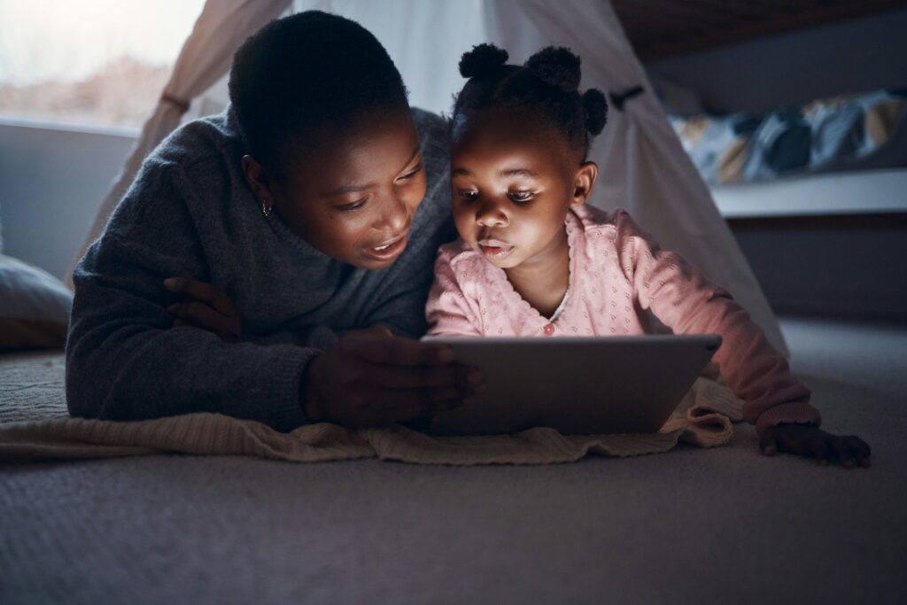 Shot of a mother reading bedtime stories with her daughter on a digital tablet